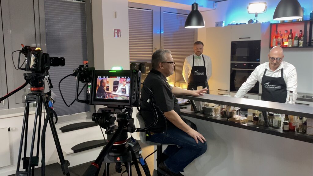 Zwei Kameras filmen Darsteller beim Kochen in der Küche